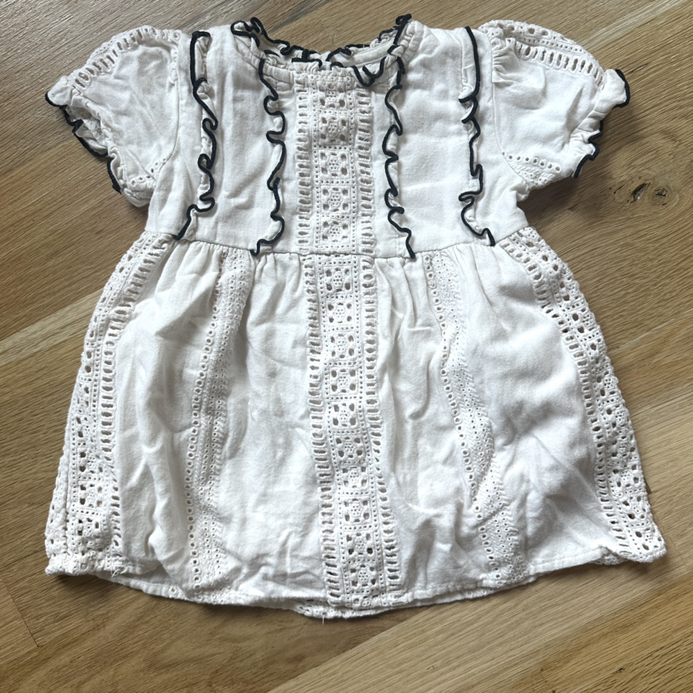 Cream Zara eyelet dress with black ruffle trim details. Size 12-18 months.